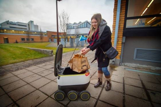 Starship toob toidu TTÜ-sse. Diana Makhova, Tallinna Tehnikaülikooli tudeng, vastu võtmas oma esimest roboti poolt kohaletoimetatud Wolti tellimust.